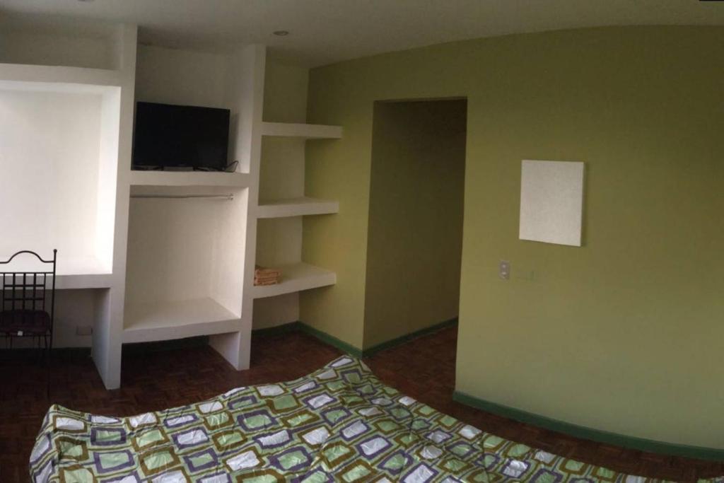 a bedroom with a bed and a tv and shelves at Beautiful Apartment San Jose Downtown South in San José