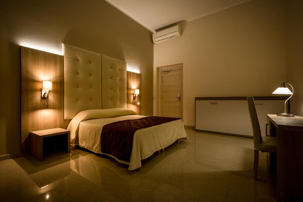 ジェノヴァにあるHotel Bel Soggiornoのベッドルーム1室(ベッド1台、テーブル、デスク付)