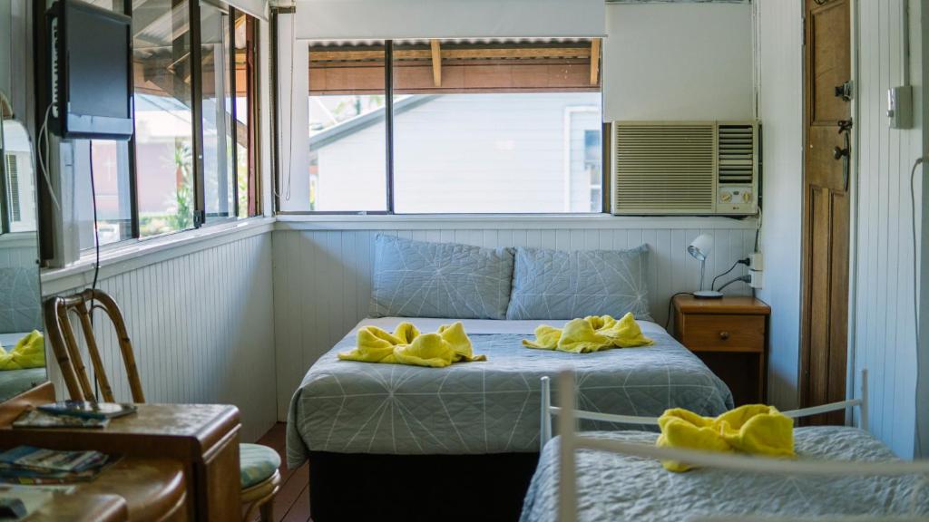 a bedroom with a bed with yellow towels on it at Ryan's Rest Boutique Accommodation in Cairns