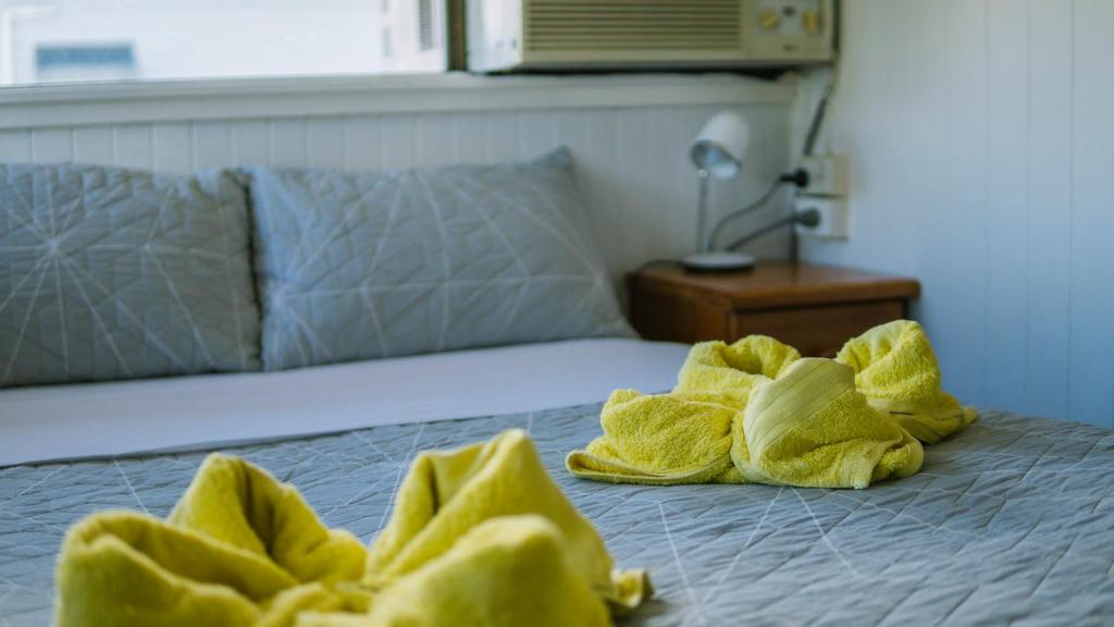 a bed with yellow towels on top of it at Ryan's Rest Boutique Accommodation in Cairns