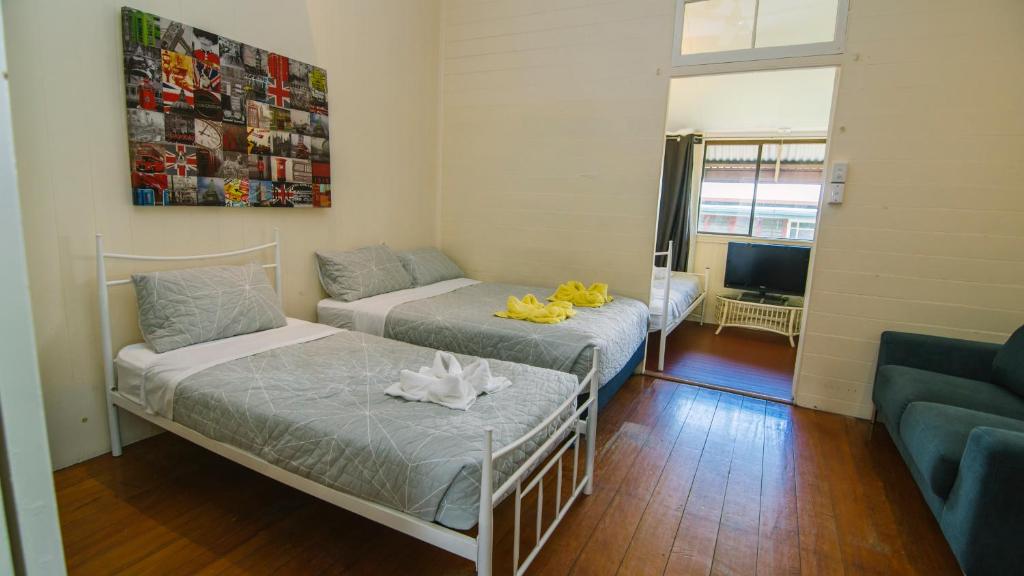 a small room with two beds and a couch at Ryan's Rest Boutique Accommodation in Cairns