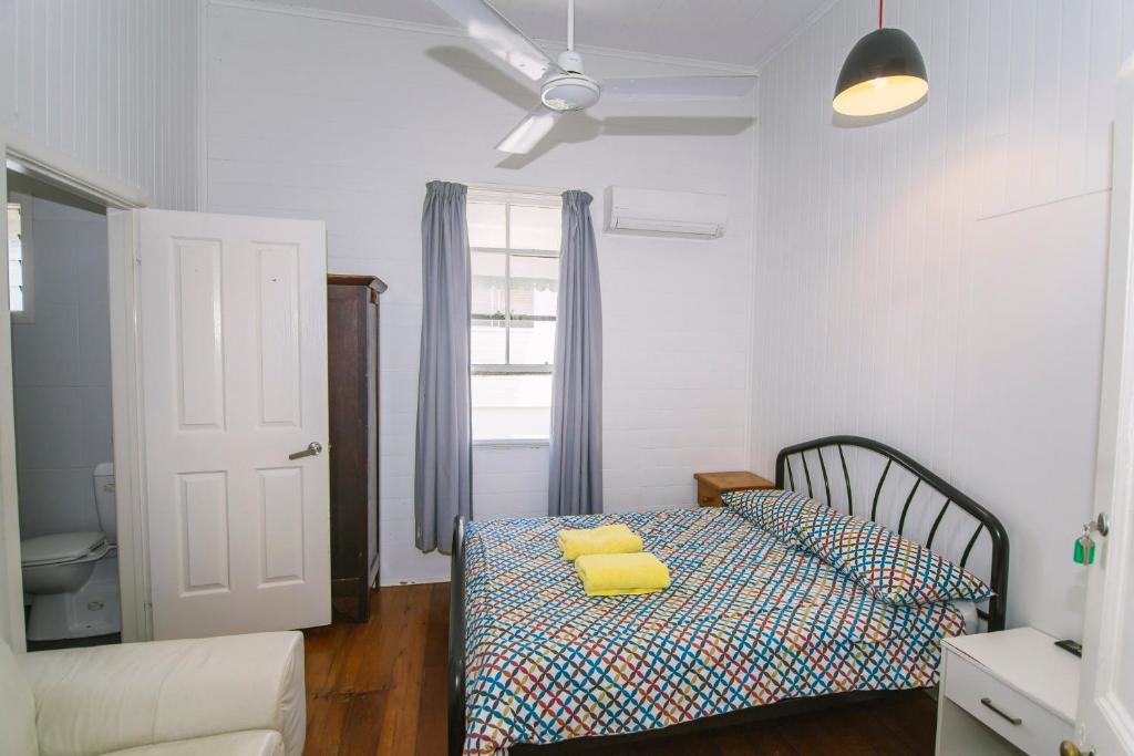 a bedroom with a bed with yellow pillows on it at Ryan's Rest Boutique Accommodation in Cairns