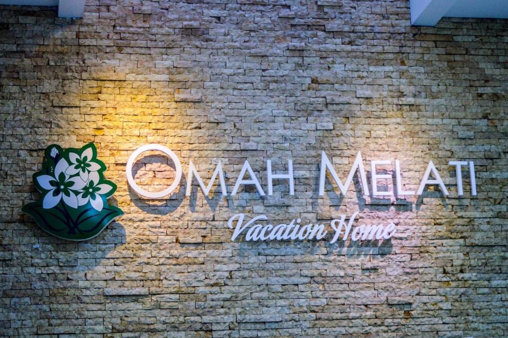 un mur en briques avec un panneau qui dit de l'art ovarien dans l'établissement Omah Melati - Vacation Home, à Solo