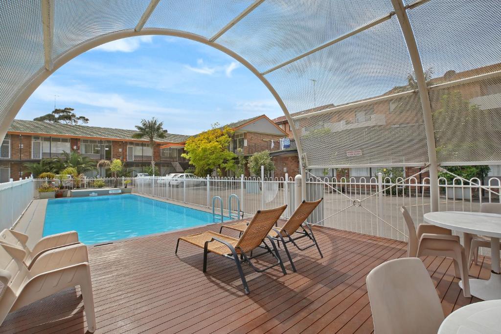 a patio with a pool and chairs and a table at Ultimate Apartments Bondi Beach in Sydney
