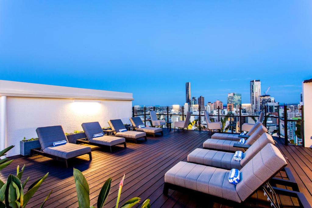 um terraço no último piso com sofás e cadeiras num edifício em Hotel Grand Chancellor Brisbane em Brisbane