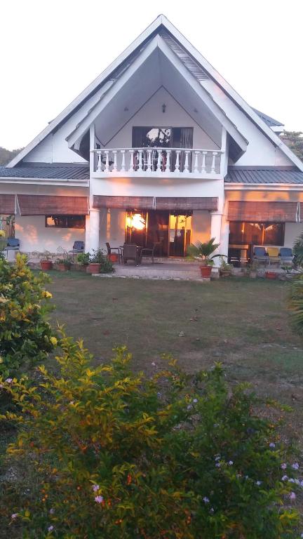 a large house with a balcony and a yard at Chello's Villa in Mahe