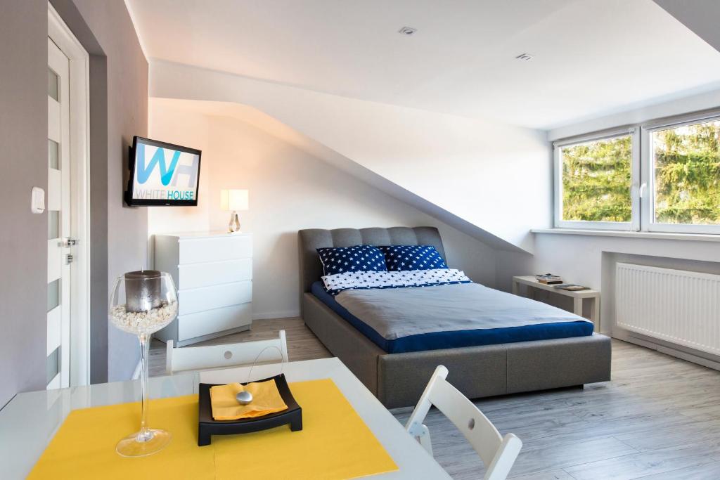 Habitación pequeña con cama y mesa de comedor. en White House, en Varsovia