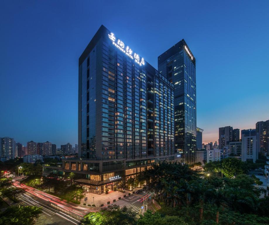 ein hohes Gebäude in einer Stadt in der Nacht in der Unterkunft Sentosa Hotel Apartment Taoyuan Branch in Shenzhen