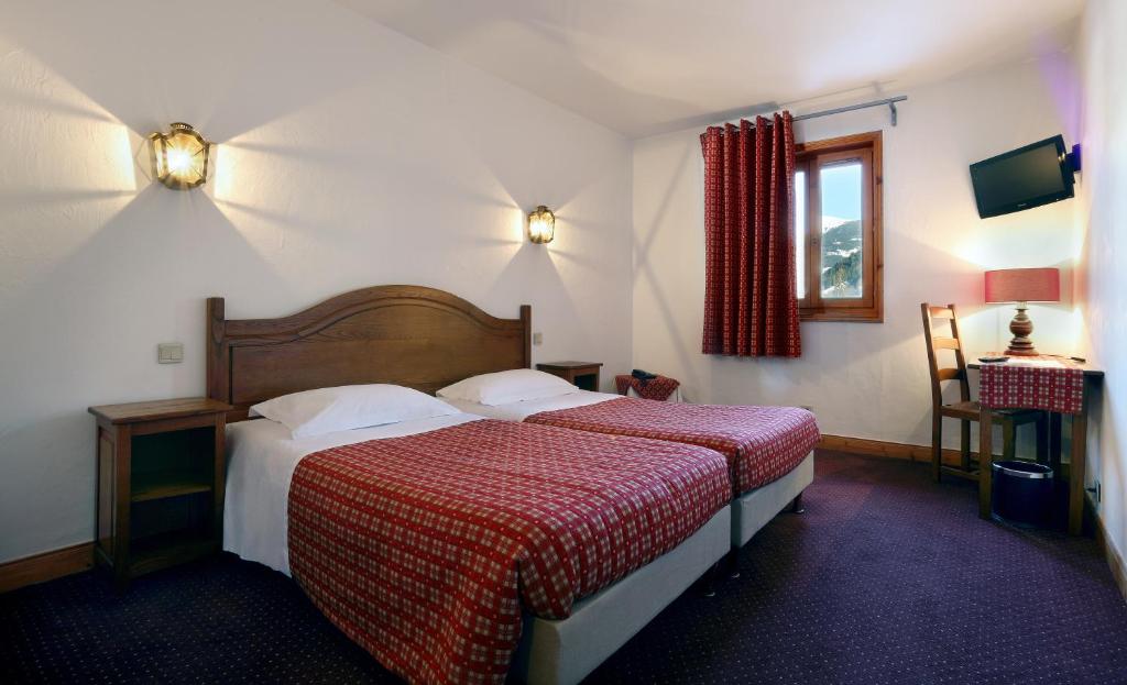 a hotel room with two beds and a window at Hotel Autantic in Bourg-Saint-Maurice