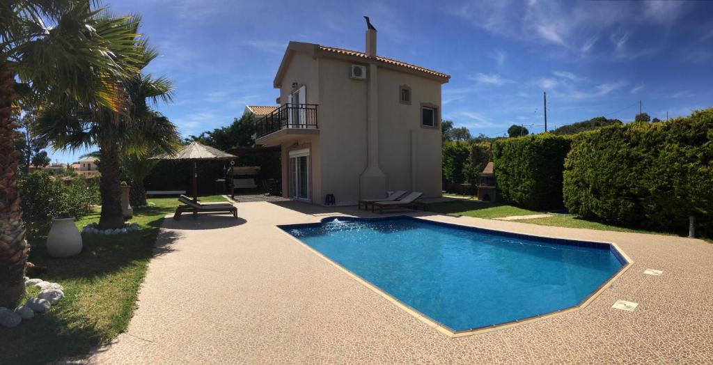 a villa with a swimming pool in front of a house at Villa AnnaMaria in Skala