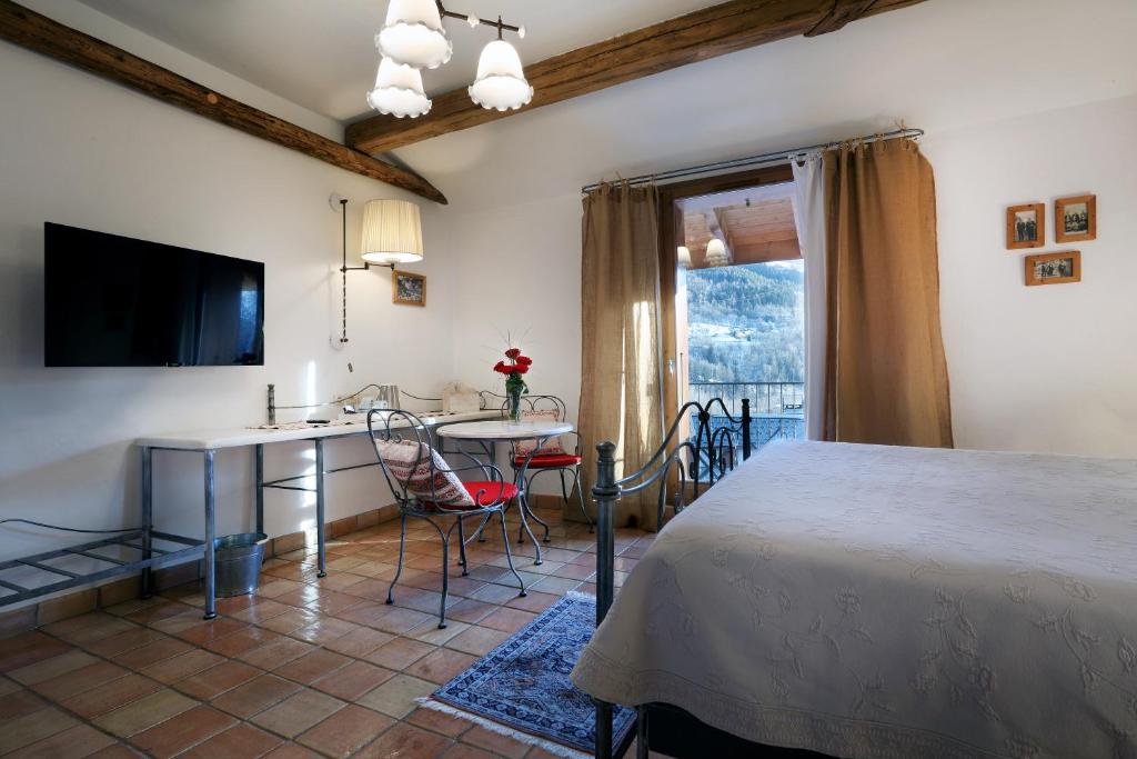 a bedroom with a bed and a table and a kitchen at Hotel Autantic in Bourg-Saint-Maurice