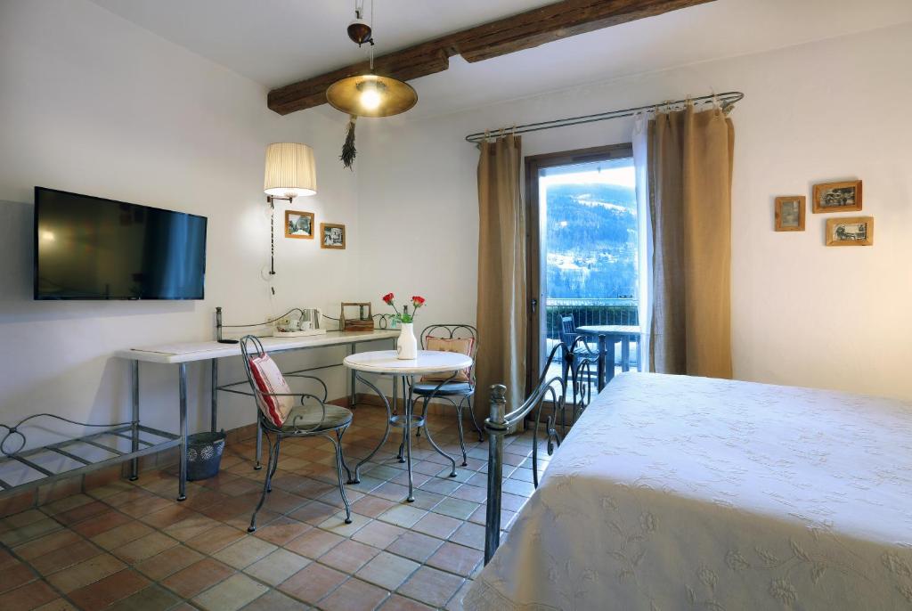 a room with a bed and a table and chairs at Hotel Autantic in Bourg-Saint-Maurice