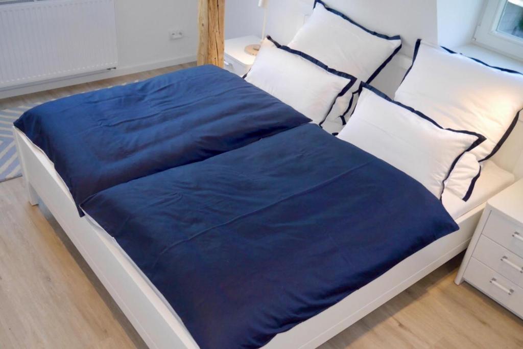 a bed with a blue blanket on top of it at Ferienwohnung Kiel - Kanalblick in Kiel