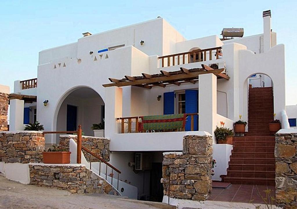 a large white house with a staircase in front of it at Dafnis Koufonisia in Koufonisia