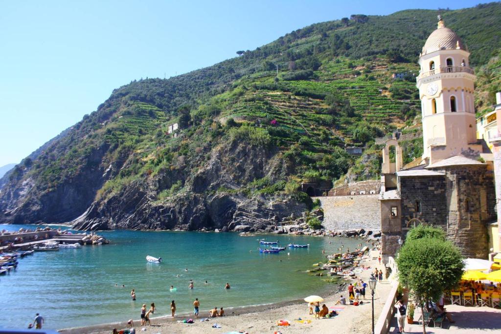 a group of people on a beach next to a mountain at Da Marcella in Vernazza