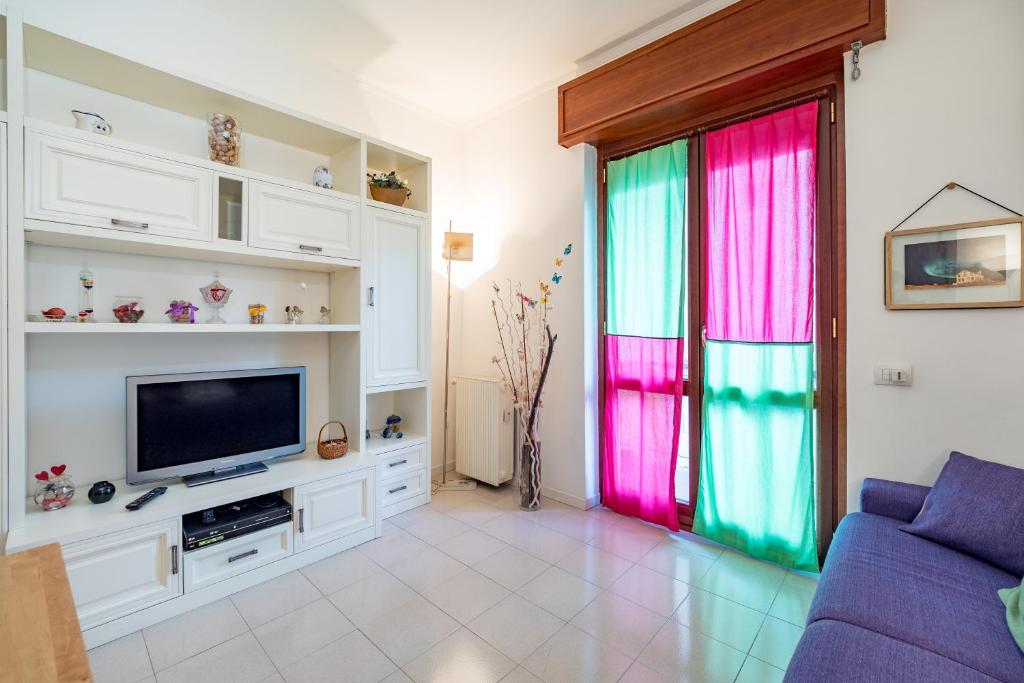 een woonkamer met kleurrijke gordijnen en een televisie bij Lizzy Apartment in Milaan