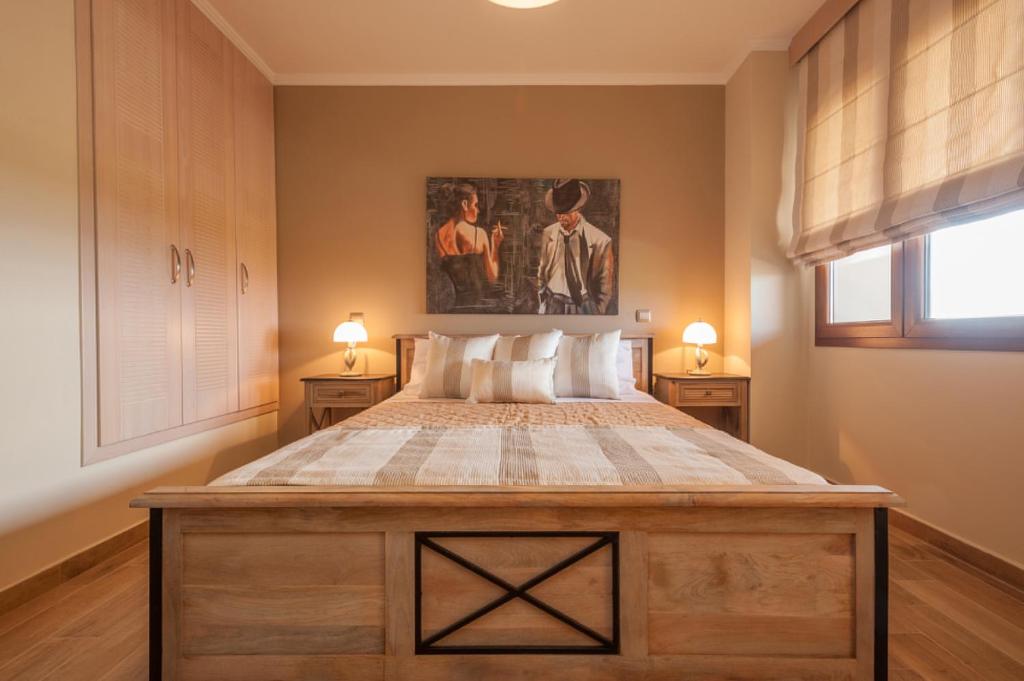 a bedroom with a large bed with two lamps at Evgatis Beach Luxury Apts in Th&aacute;nos