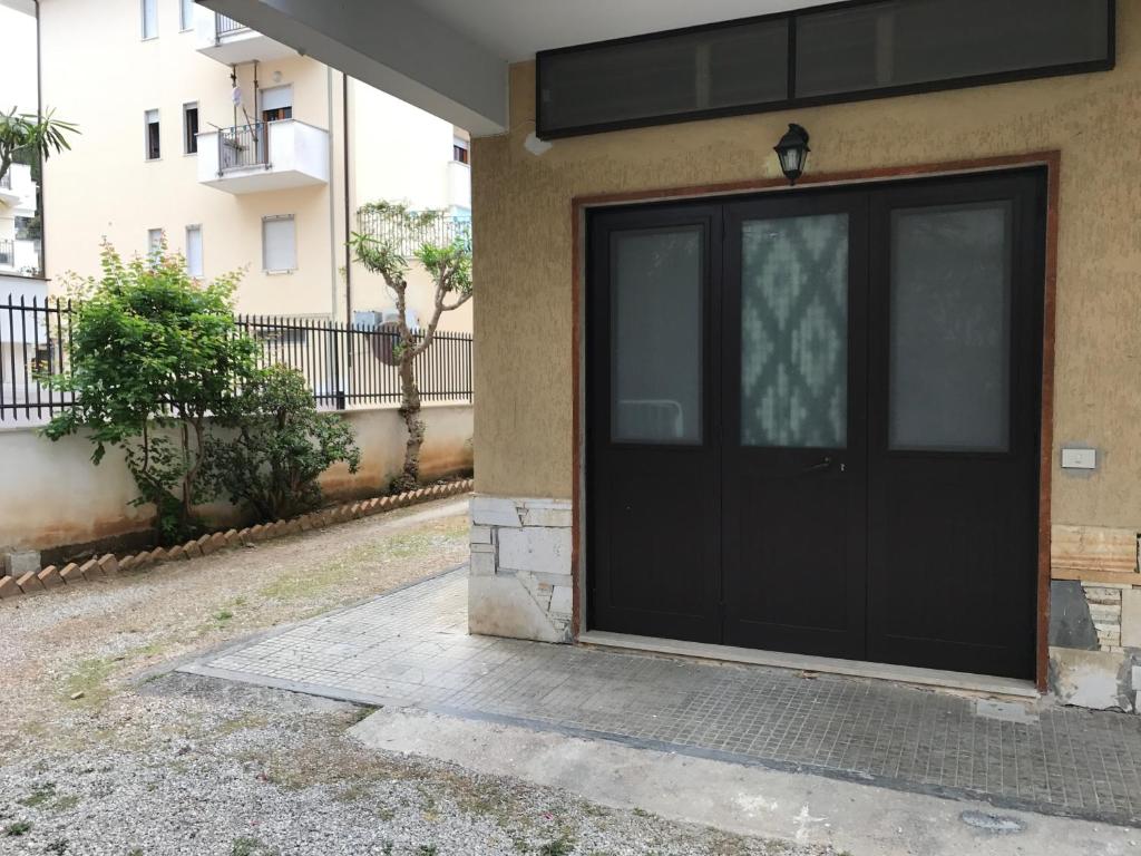 a black garage door on the side of a building at Flat Low cost in Sperlonga
