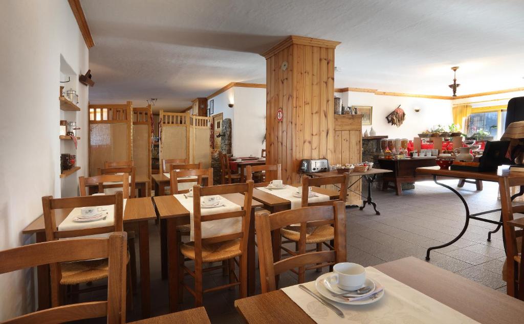 a restaurant with wooden tables and wooden chairs at Hotel Autantic in Bourg-Saint-Maurice