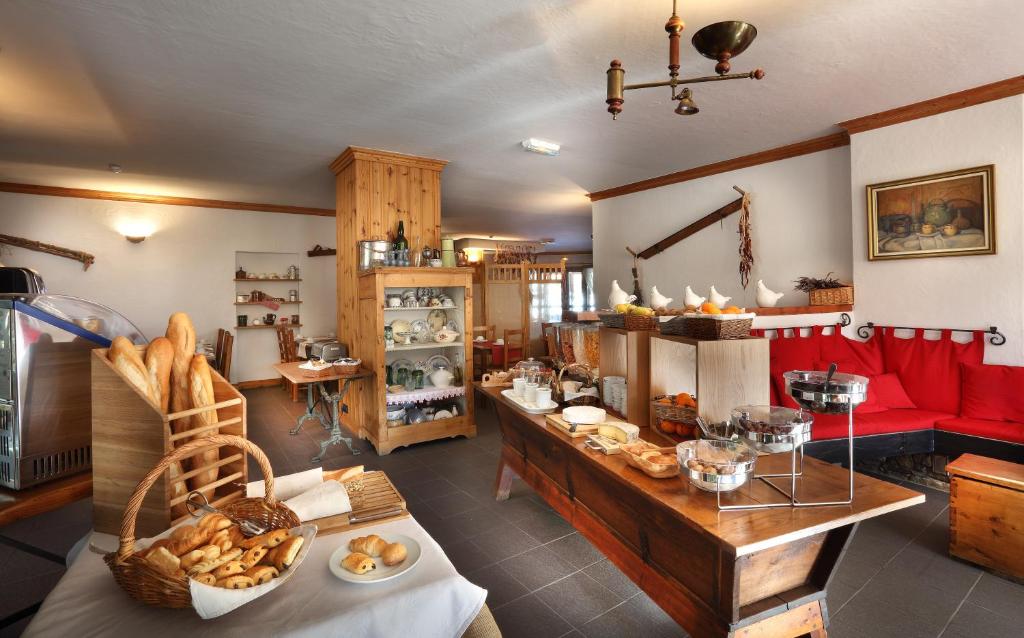 a room with a table with bread and a red couch at Hotel Autantic in Bourg-Saint-Maurice
