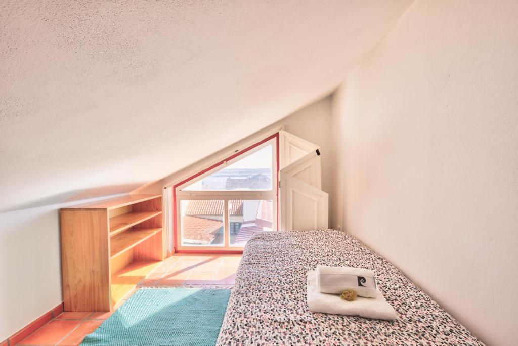コスタ・ノヴァにあるCasa Do Bicoのベッドルーム1室(ベッド1台、本付)