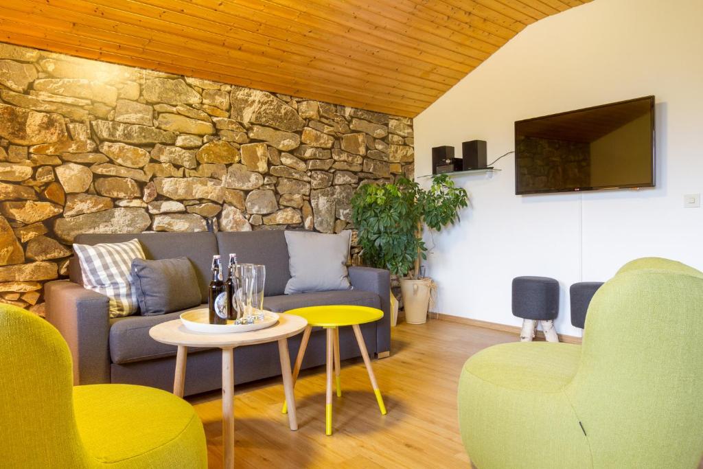 a living room with a couch and a stone wall at Ferienwohnungen Alpentraum - Landhaus Schmetterling in Oberstdorf