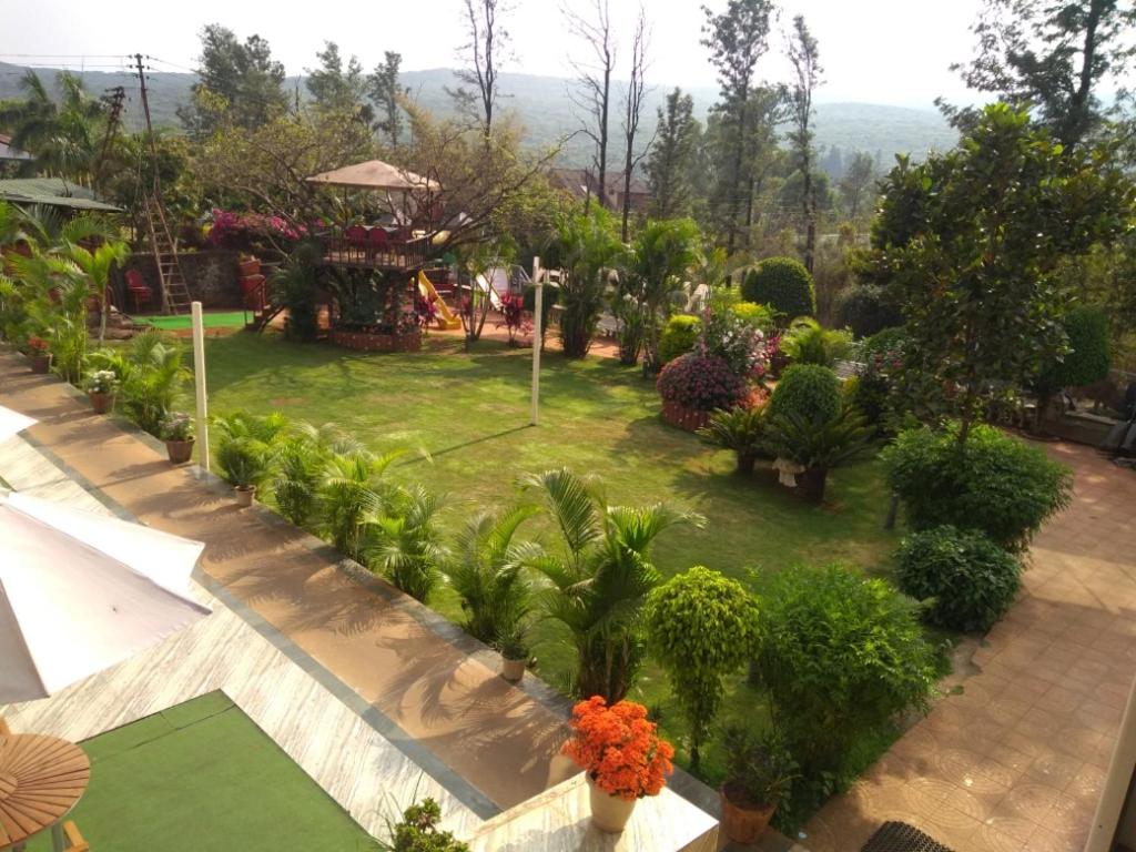 een tuin met bomen, planten en bloemen bij King Garden in Mahabaleshwar