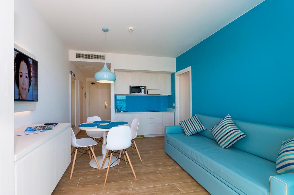 a living room with a blue couch and a table at Hotel Montecarlo in Bibione