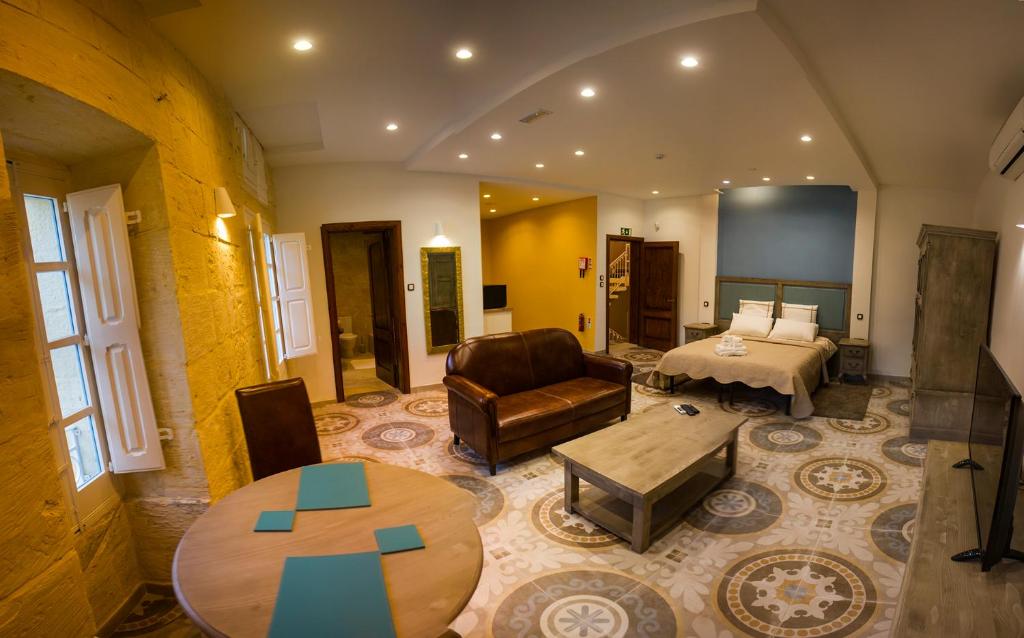 ein Wohnzimmer mit einem Sofa, einem Bett und einem Tisch in der Unterkunft Casa Azzopardi Guesthouse in Rabat