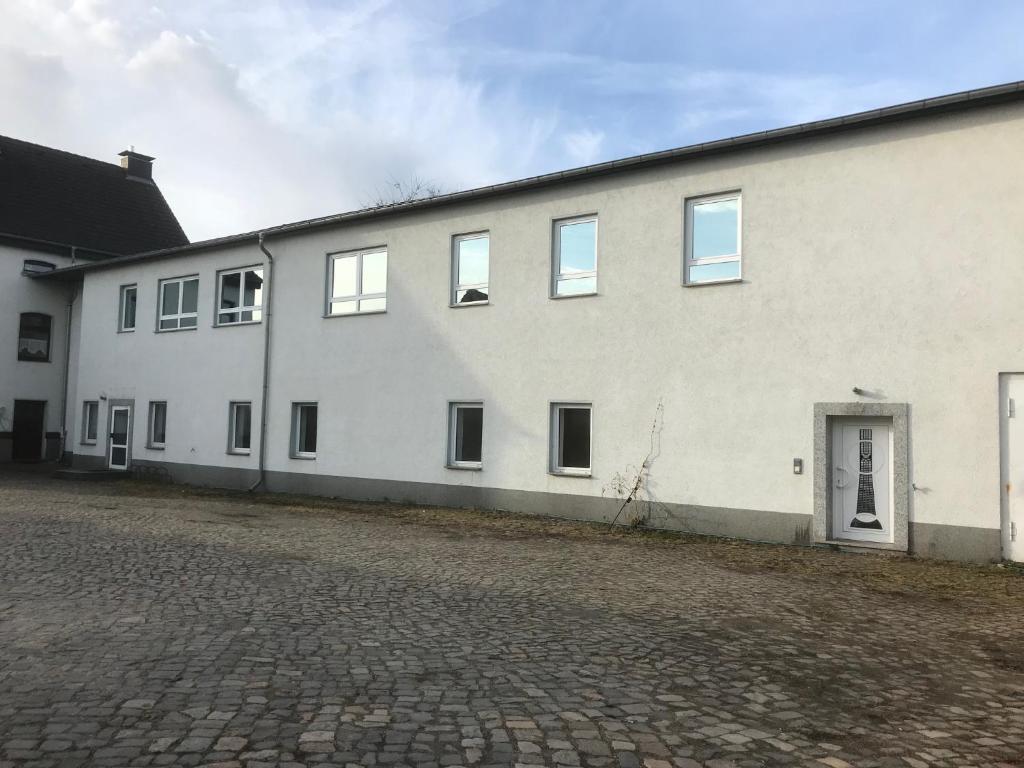 un gran edificio blanco con puerta y ventanas en Am Bahnhof, en Lutherstadt Wittenberg