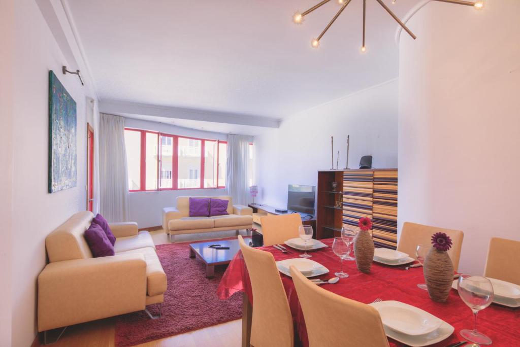 a living room with a table and chairs at Welcome Barra Apartment in Gafanha da Nazaré