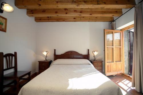 a bedroom with a large bed and a window at Casa Rural Soportales de Peguerinos in Peguerinos