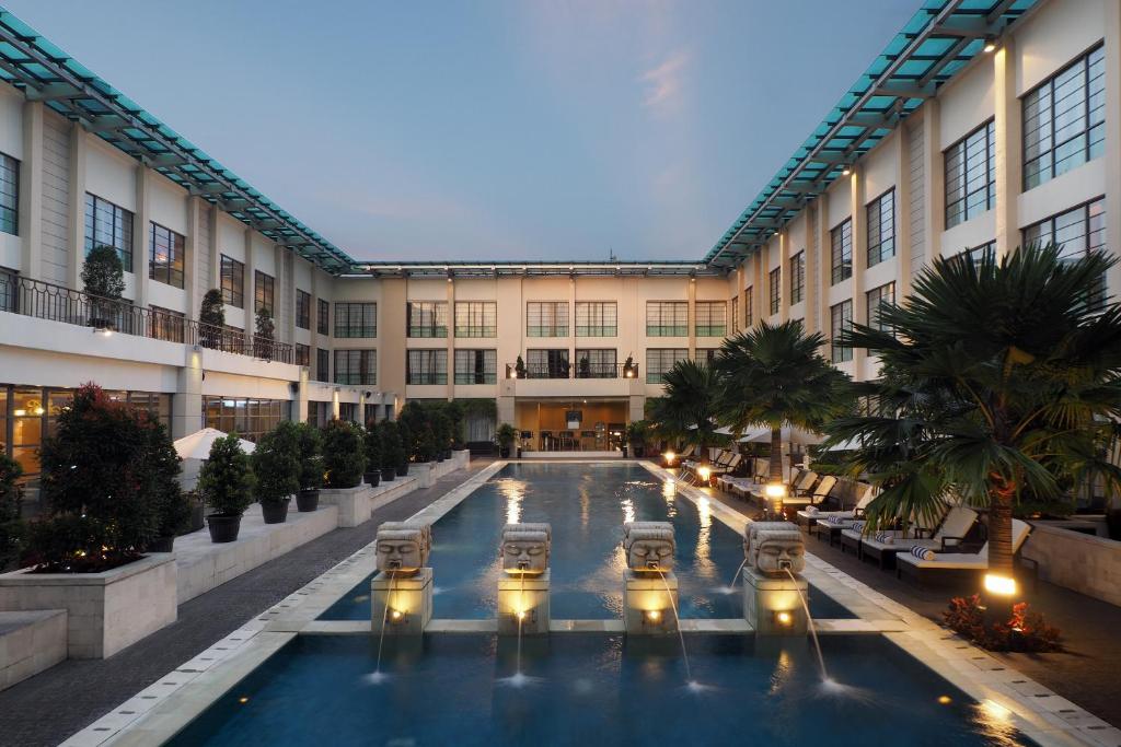 an indoor courtyard of a building with a swimming pool at Aryaduta Medan in Medan