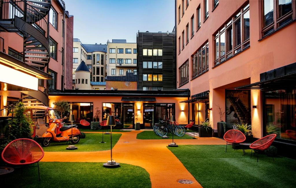 einen Innenhof eines Apartmenthauses mit Stühlen und einem Roller in der Unterkunft Hotel F6 in Helsinki