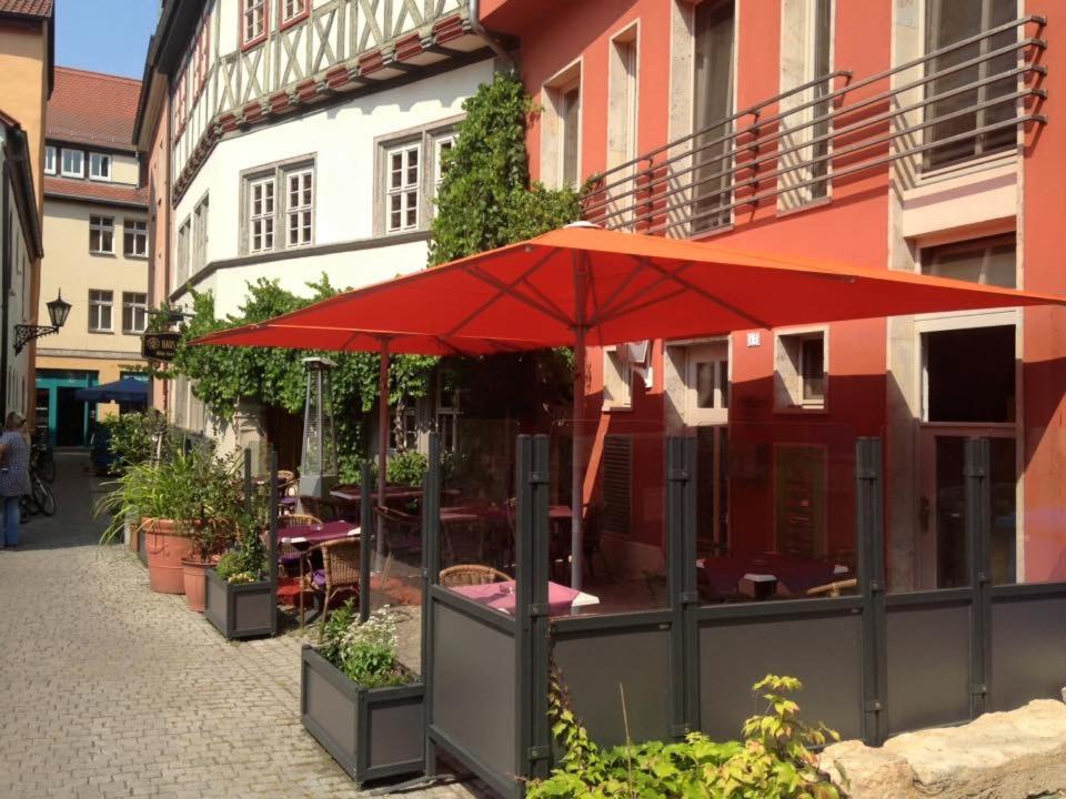 a red umbrella sitting outside of a building at 3 Raum Ferienwohnung in Jena