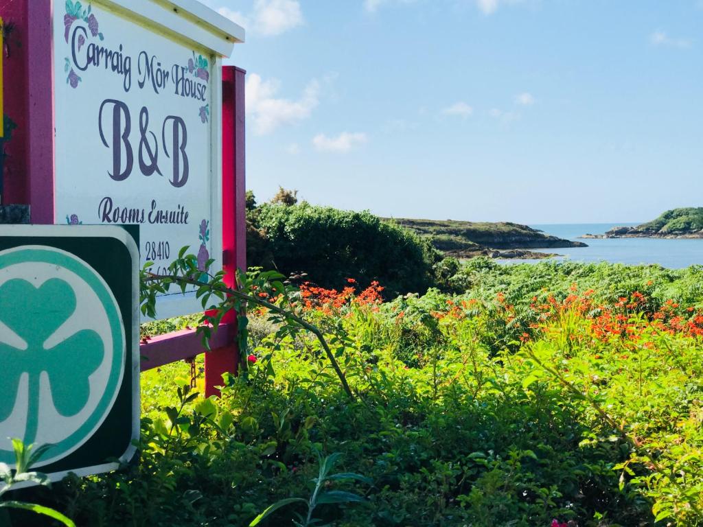 um sinal para um restaurante bop com o oceano ao fundo em Carraig-Mor House Bed & Breakfast em Toormore