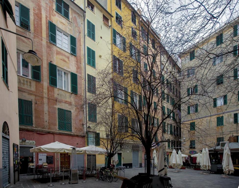 een groep gebouwen met tafels en parasols op een binnenplaats bij Lavagna Uno in Genua