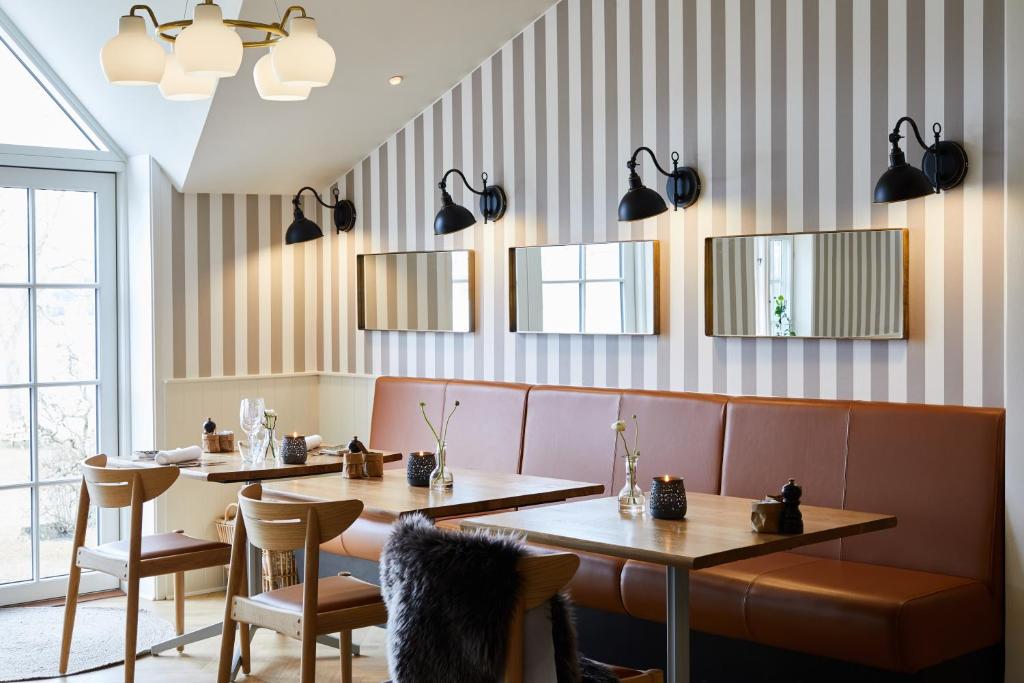 a restaurant with two tables and chairs and mirrors at Gl. Avernæs Sinatur Hotel & Konference in Ebberup
