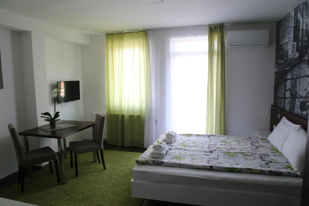 1 dormitorio con cama, mesa y ventana en SAPA Studios & Apartments, en Niš