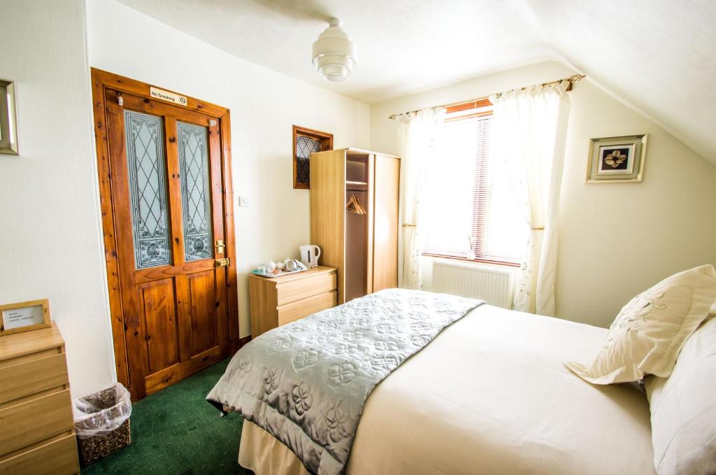 1 dormitorio con cama blanca y ventana en Anchorage B&B, en Cockenzie