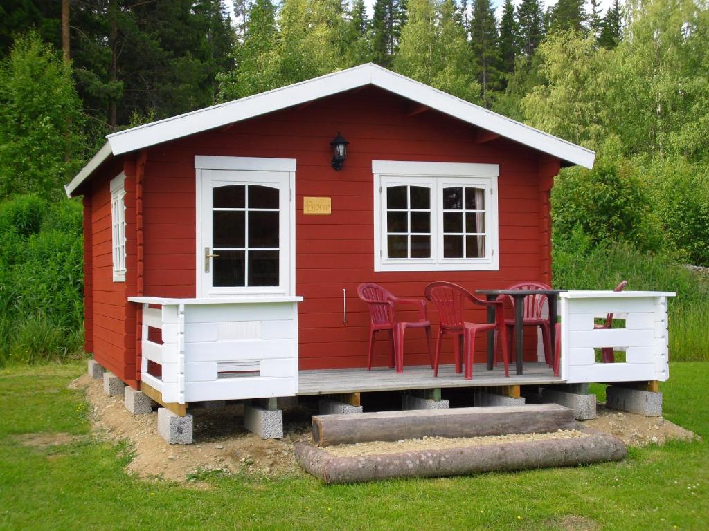 Czerwony domek zabaw z czerwonymi krzesłami w obiekcie stuga Björn w mieście Vigge