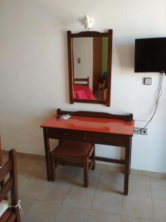 toaletka z lustrem i czerwonym biurkiem w obiekcie Flamingo Apartments w mieście Palekastron