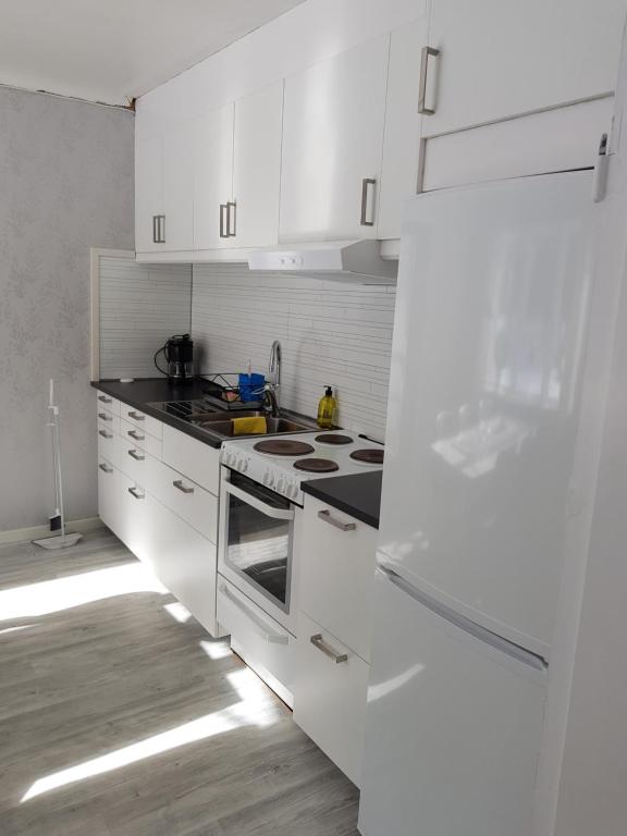 cocina con armarios blancos y fogones en Voxnabruks Kanot & Camping, en Voxnabruk