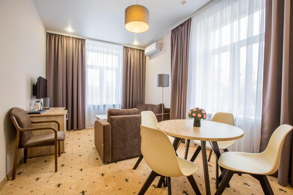 sala de estar con mesa, sillas y sofá en Yaroslavskaya Hotel, en Moscú