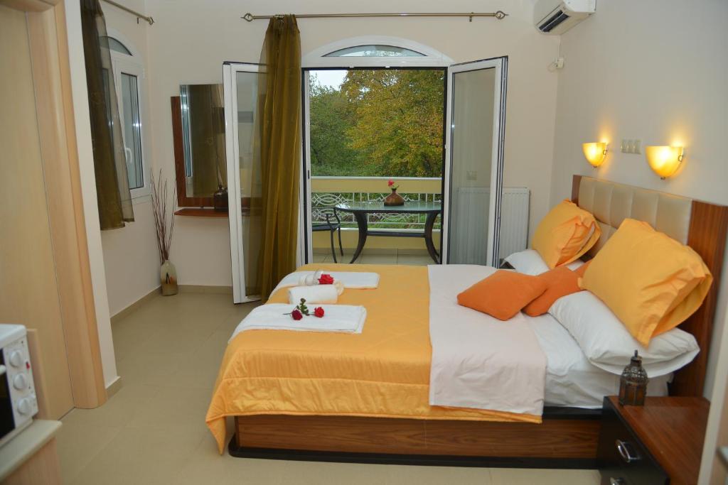 ein Schlafzimmer mit einem großen Bett und einem Balkon in der Unterkunft Royal's Studios in Loutra Edipsou