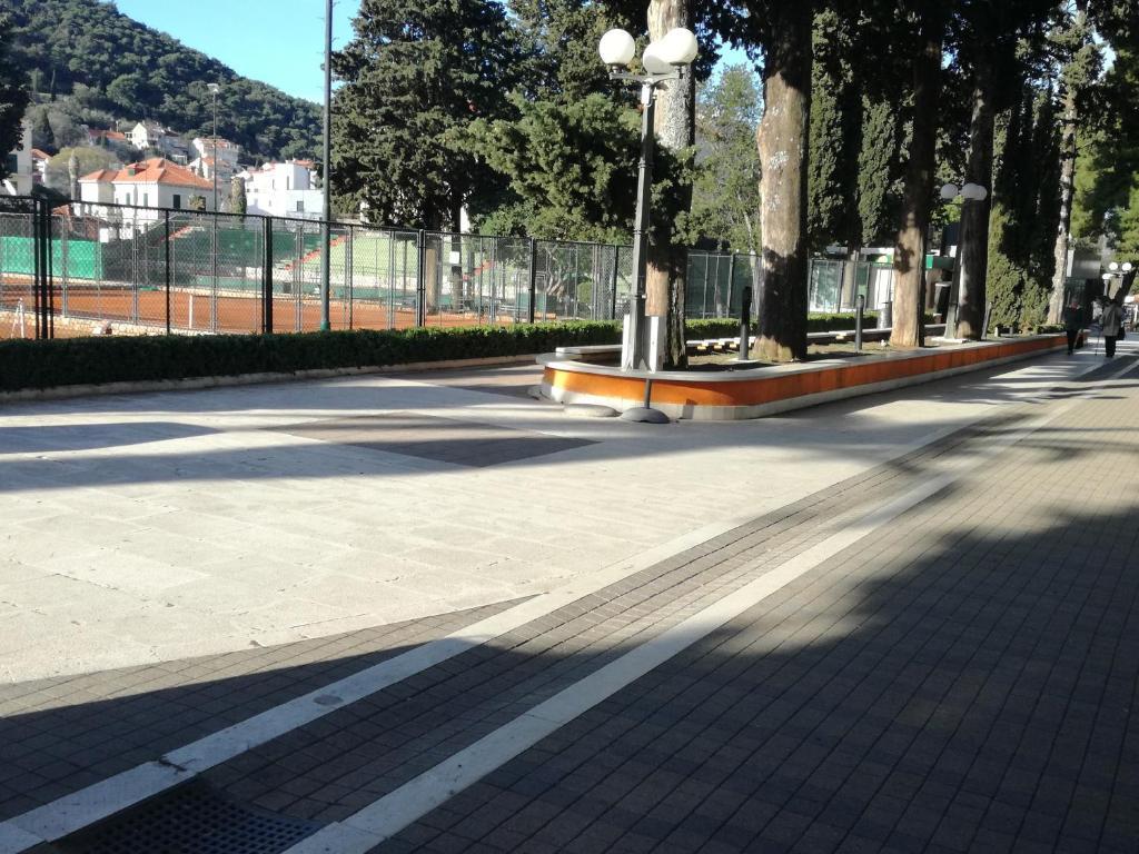a sidewalk with trees and a fence in a park at Ana Guesthouse in Dubrovnik