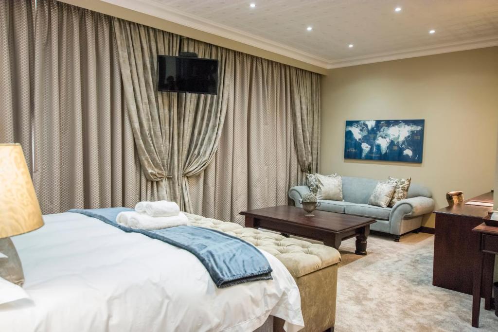 a hotel room with a bed and a couch at Border Hotel in Jan Kempdorp