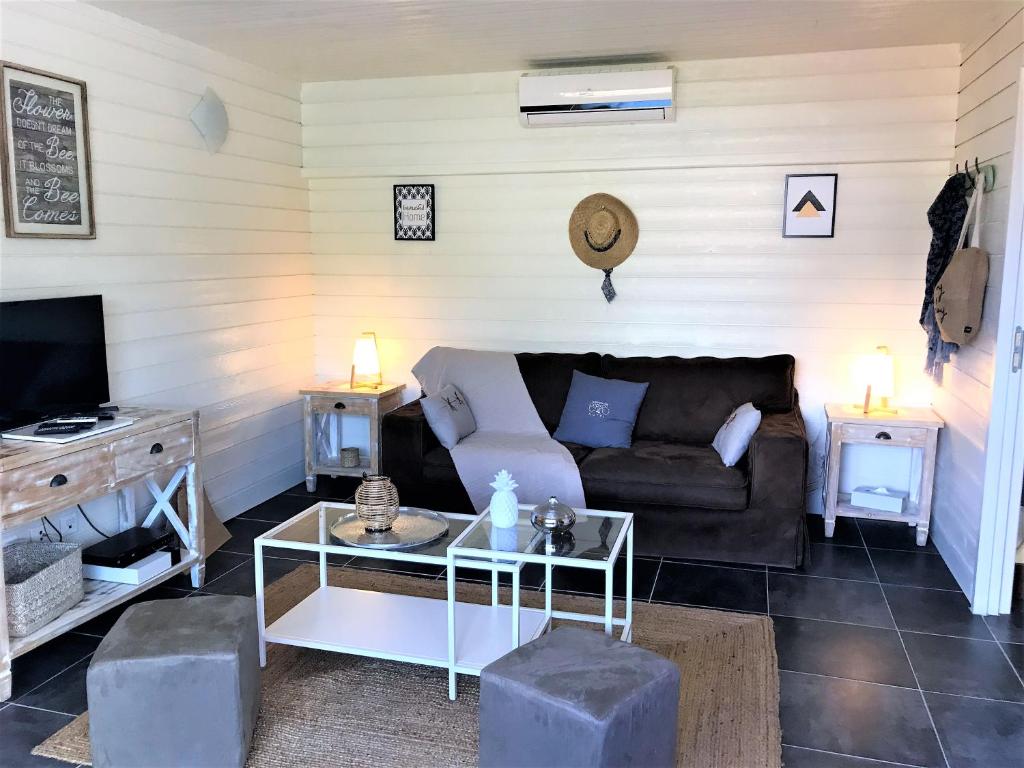 a living room with a couch and a tv at Studio La Voile Blanche in Orient Bay French St Martin