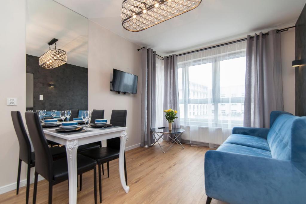 - un salon avec une table et un canapé bleu dans l'établissement Apartment Royal V, à Białystok