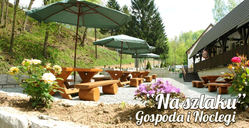 a group of benches and umbrellas next to a building at Gospoda i Noclegi Na szlaku in Kudowa-Zdrój